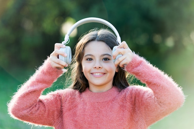 Het enige wat ze wil horen is muziek Schattig klein meisje buiten Klein meisje dat een koptelefoon draagt Gelukkig kind geniet van het luisteren naar muziek onderweg Ongelooflijk geluid voor al haar entertainment