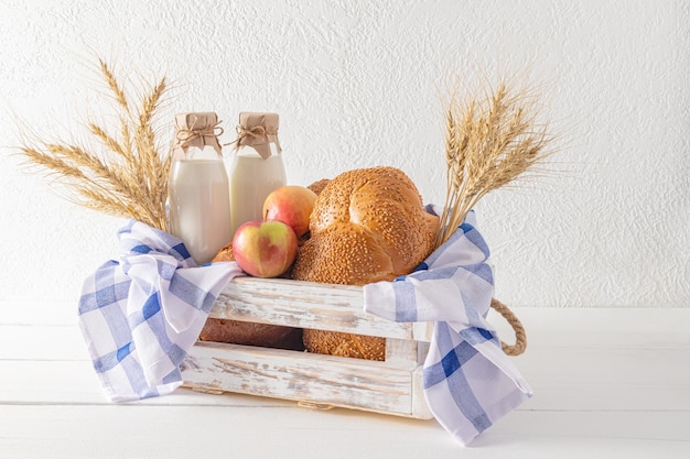 Het feest van het geven van Torah twee flessen verse melk en vers gebakken brood in een houten doos met een handdoek het concept shavuot