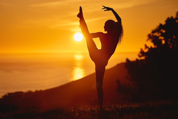 Het gaat erom je grenzen te verleggen Volledige opname van een onherkenbare en atletische jonge vrouw die buiten yoga beoefent bij zonsondergang