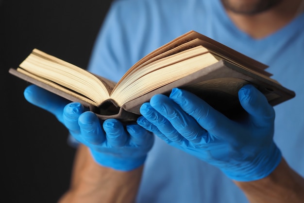 Het gebedsboek bij mensen dient blauwe medische handschoenen in.