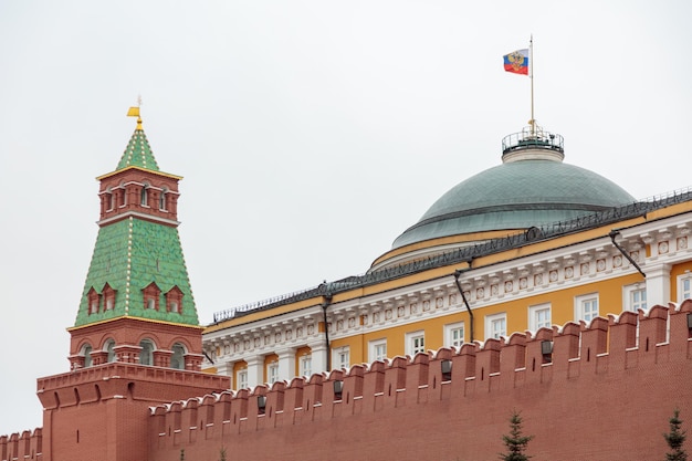 Het gebouw van het Kremlin is een rode bakstenen muur en een koepel met een vlag erop.