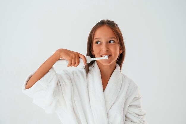 Het gebruik van de tandenborstel Conceptie van schoonheid en zelfzorg Jong meisje is in de studio