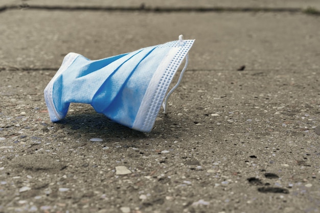 Het gebruikte masker ligt op de weg, van dichtbij