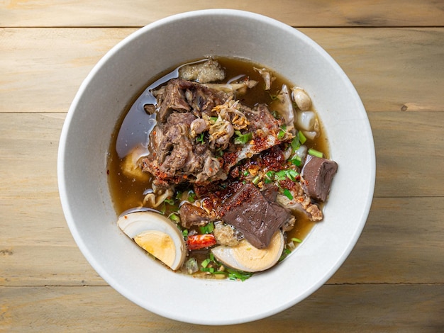 Het gekookte Chinese pastavierkant op houten tafel voor het concept van straatvoedsel Azië