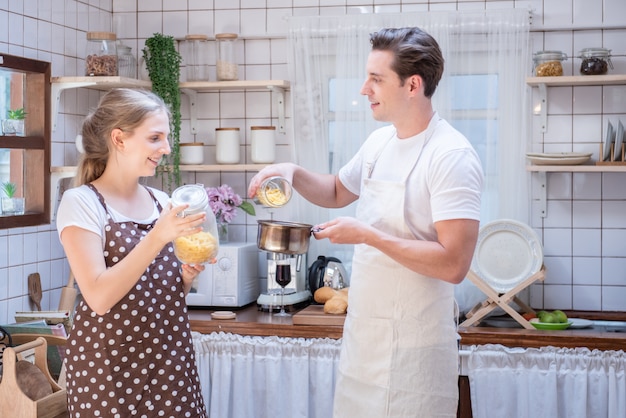 Het gelukkige kaukasische paar koken in moderne keuken