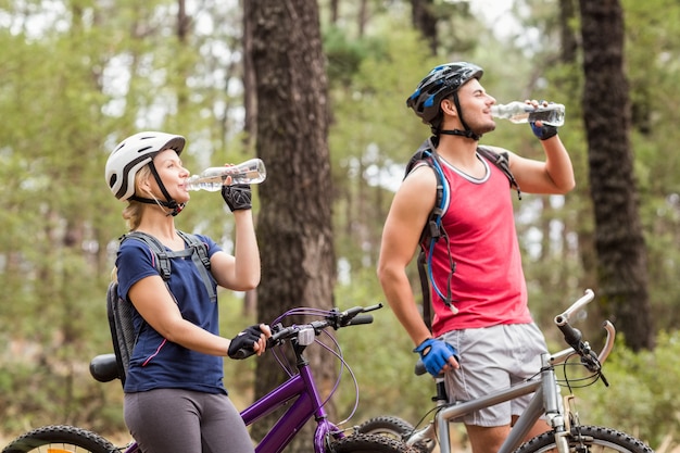 Het gelukkige knappe drinkwater van de fietserpaar