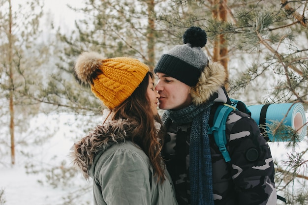 Het gelukkige kussende paar in liefde bij het bosaardpark in koud seizoen