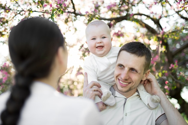 Het gelukkige man en vrouwen spelen met baby in openlucht