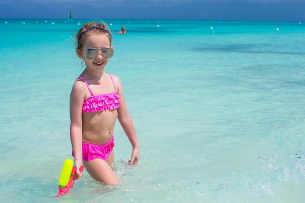 Het gelukkige meisje spelen met speelgoed tijdens caraïbische vakantie