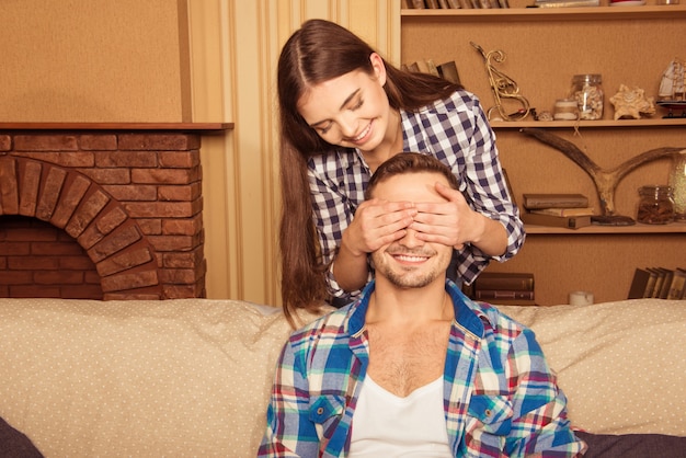 Het gelukkige meisje verraste haar vriend en bedekte zijn ogen met haar handen