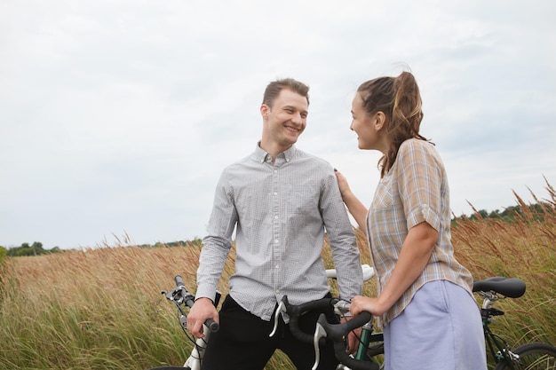 Het gelukkige paar fietsen in de buurt van het veld