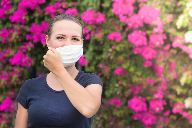 Het gelukkige positieve meisje, jonge mooie vrouw stijgt beschermend steriel medisch masker op