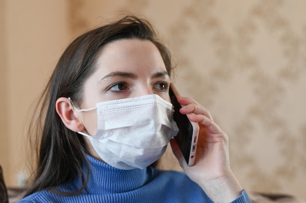 Het gemaskerde meisje belt de dokter. eerste tekenen van coronavirus