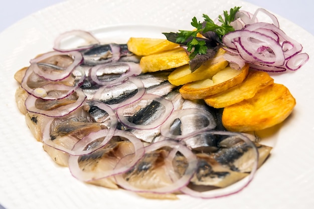 Het gerecht met aardappelen en gezouten vis. het eten in het restaurant