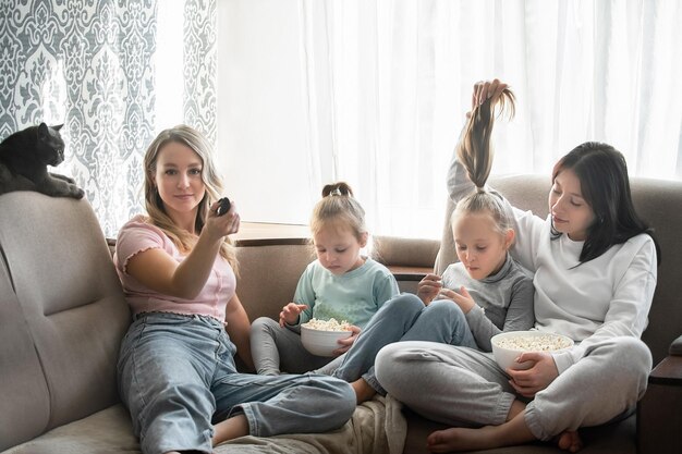 Het gezin brengt de dag samen thuis door. Vier meisjes van verschillende leeftijden zitten samen op de bank ea