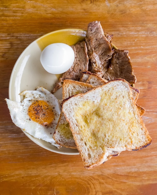 Het gezonde ontbijt met gebakken ei, gekookt ei, gegrilde runderlende, gegrild en toast