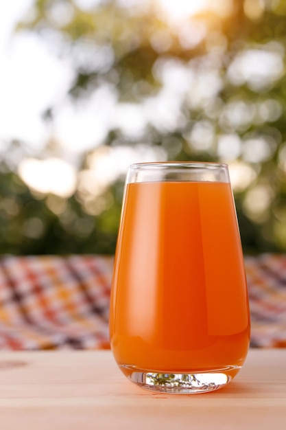 Het glas sap in een tuin De houten tafel