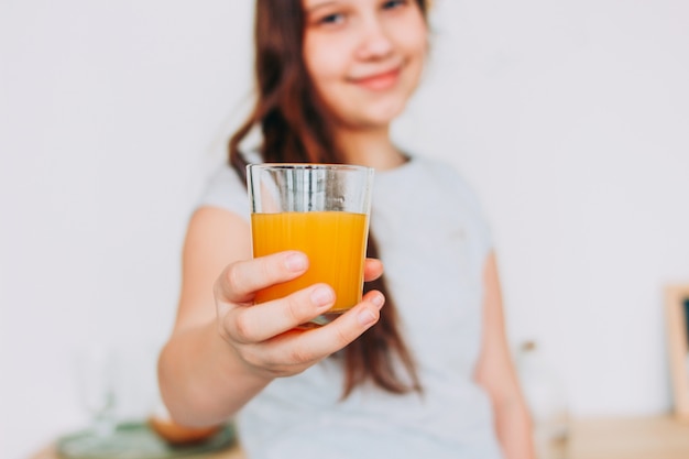 Het glas van de meisjesholding ter beschikking sinaasappelsap, selectieve nadruk