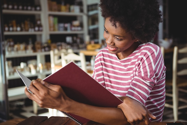 Het glimlachen van het menu van de vrouwenlezing in koffie