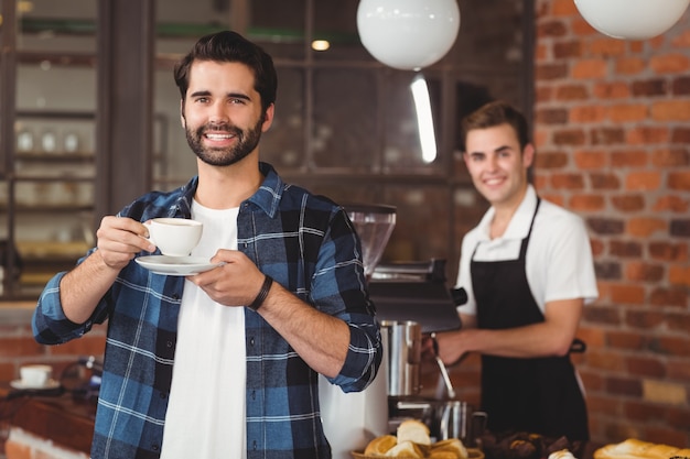 Het glimlachen van hipster het drinken koffie voor barista