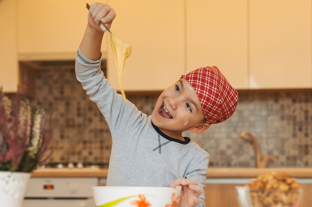 Het glimlachen van jongens kokend deeg voor cake