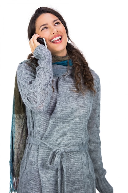 Het glimlachen van vrij brunette die de winterkleren dragen die telefoongesprek hebben