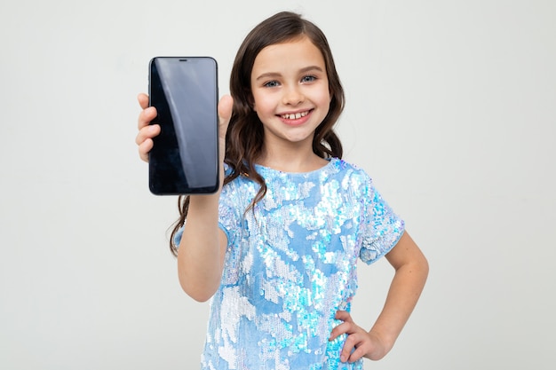 Het glimlachende meisje toont het leeg scherm met een model op een wit