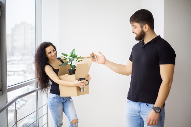 Het glimlachende paar pakt dozen in nieuw huis uit.