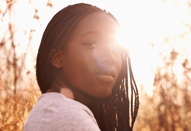 Het gouden uur Portret van een aantrekkelijk tienermeisje in een veld met de zon achter haar