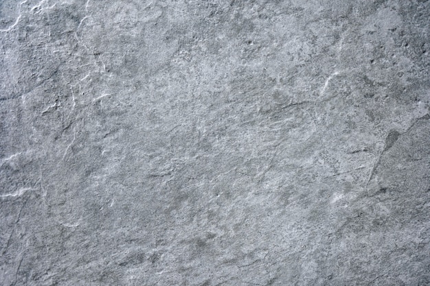 Het grijze cementbeton van de steentextuur, rots gepleisterd muurstucwerk, schilderde vlakke langzaam verdwijn achtergrond van marmeren grijze stevige vloerkorrel. Ruwe grafiet keramische tegel. Decoratie voor thuis.