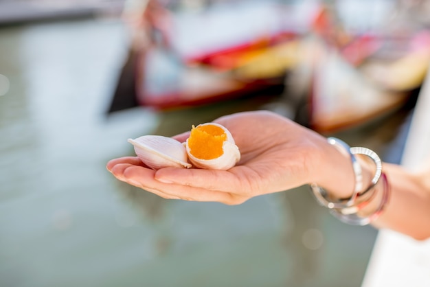 Het houden van Portugese delicatesse genaamd Ovos Moles gemaakt van eidooiers en suiker op de achtergrond van het waterkanaal in de stad Aveiro, Portugal