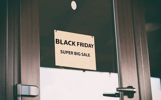 Het houten bord met de tekst black friday sale hangt aan de deur in de winkel