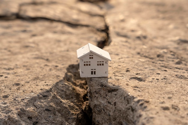 Het huis viel in een scheur tijdens een aardbeving Aardbeving woningverzekering concept Val van onroerend goed