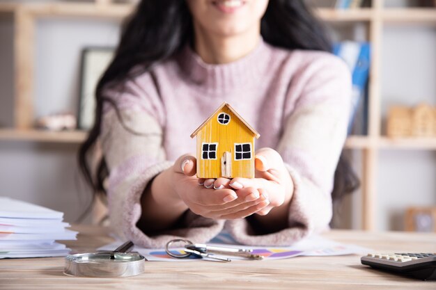 Het huismodel van de vrouwenholding in bureau, Concept van de bouw