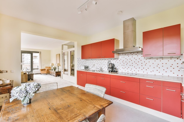 Het interieur van een ruime lichte keuken in een rood design met veel lockers en moderne toestellen