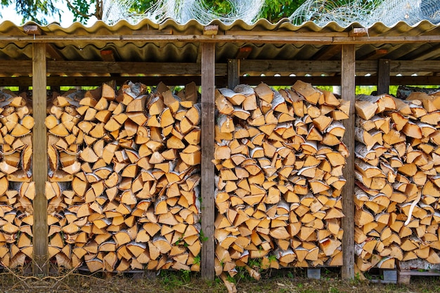 Het interieur van een rustieke schuur gevuld met brandhout voor de winterverwarming