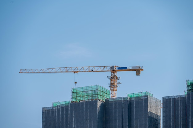 Het is een mooie dag met een blauwe lucht en de torenkraan op de hoogbouw in de stad is in aanbouw