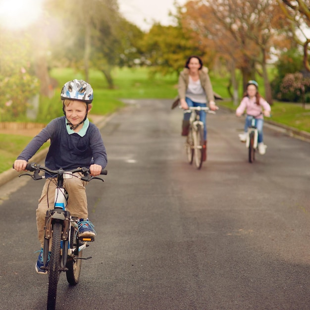 Het is een mooie dag voor een fietstocht Shot van een moeder en haar twee jonge kinderen die buiten op hun fiets fietsen
