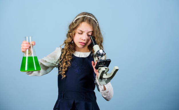 Het is een ongelooflijke kleine meisjeswetenschapper met testfles kennis kind studie biologie les Ontdek toekomstig wetenschappelijk onderzoek in het laboratorium Klein geniaal meisje met microscoop terug naar school