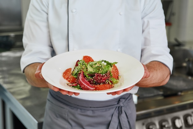 Het is goed humeur eten close-up van chef-kok gekookte salade