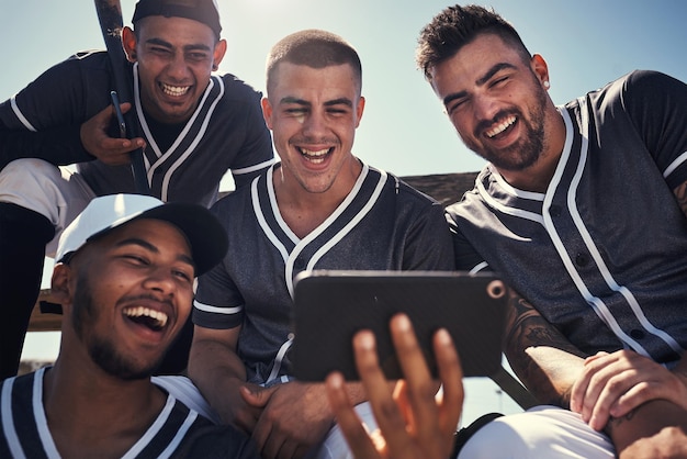 Foto het is hoe honkbalspelers een band vormen shot van een groep jonge mannen die een smartphone gebruiken na het spelen van een honkbalwedstrijd