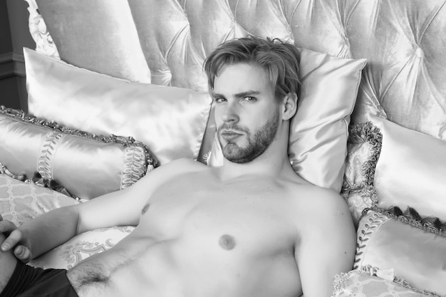 Het is weer ochtend single man wakker in de ochtend sexy man ligt in bed geniet van elke dag