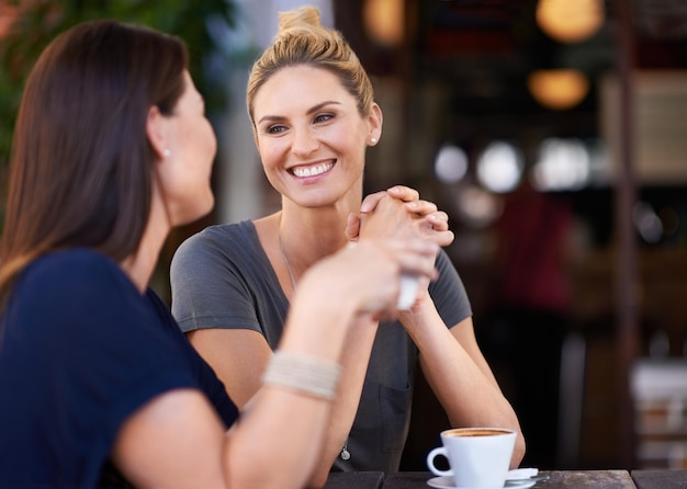 Het is zo goed om je weer te zien Twee aantrekkelijke vrouwen die buiten een café zitten