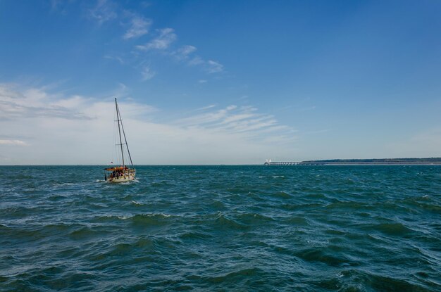 Het jacht vaart op een ruwe zee.