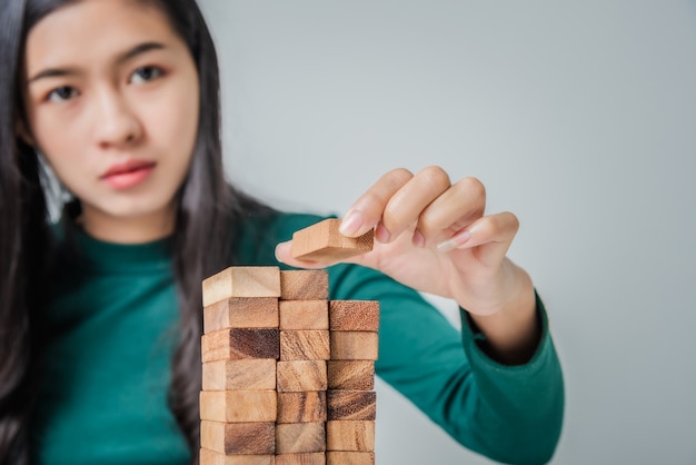 Foto het jonge bedrijfsvrouw aziatische spelen met houten blokken