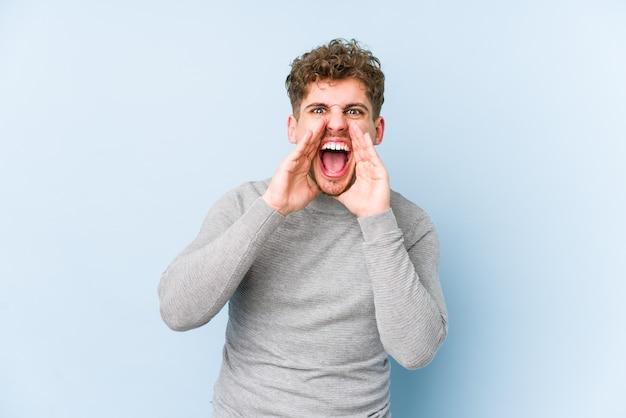 Het jonge blonde krullende haar Kaukasische mens geïsoleerde schreeuwen opgewekt aan voorzijde.