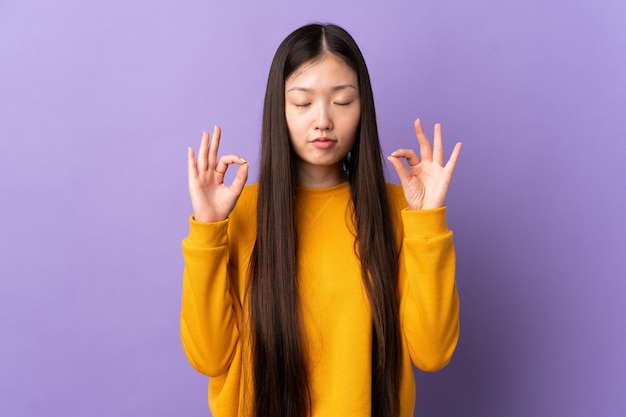 Het jonge Chinese meisje over geïsoleerde purper in zen stelt