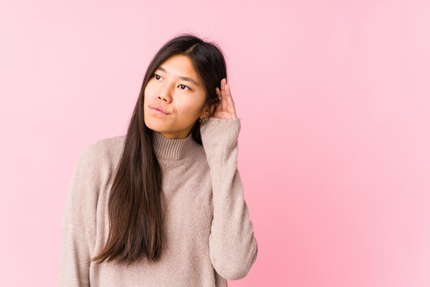 Het jonge Chinese vrouw stellen die een roddel proberen te luisteren.