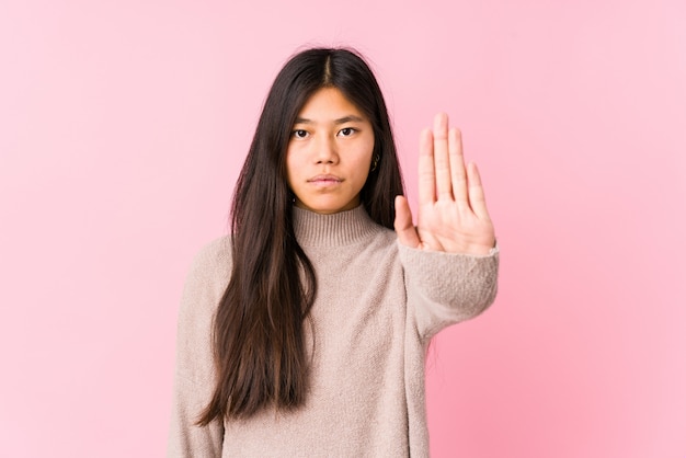 Het jonge Chinese vrouw stellen geïsoleerde status met uitgestrekte hand die eindeteken tonen, die u verhinderen.