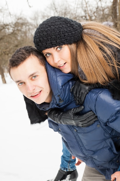 Het jonge gezin speelt winterhout op sneeuw